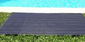 tapis solaire piscine noir sur gazon vert avec piscine bleue